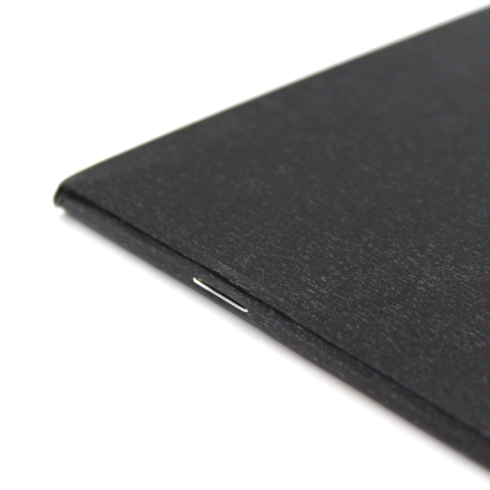 Close Up Of The Staple Binding On A3 Field Black Sketchbook 140gsm Paper On A White Background