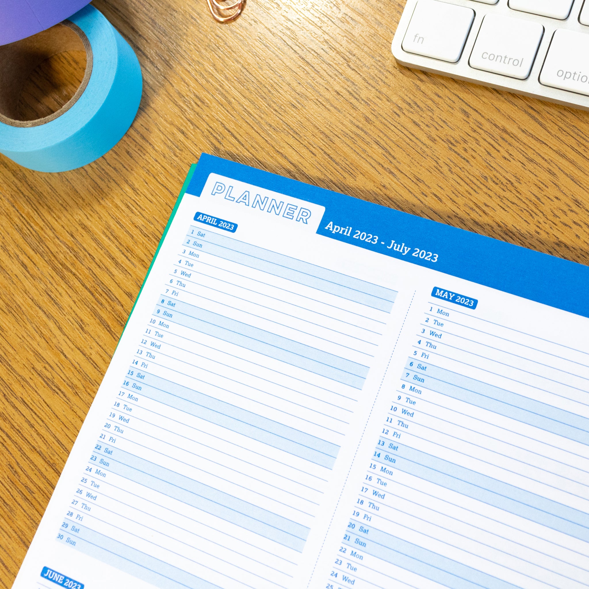 Flexi Period Teacher Planner Open On Calendar Pages On A Wooden Desk With Blue & Purple Wash Tape & A Keyboard In The Background