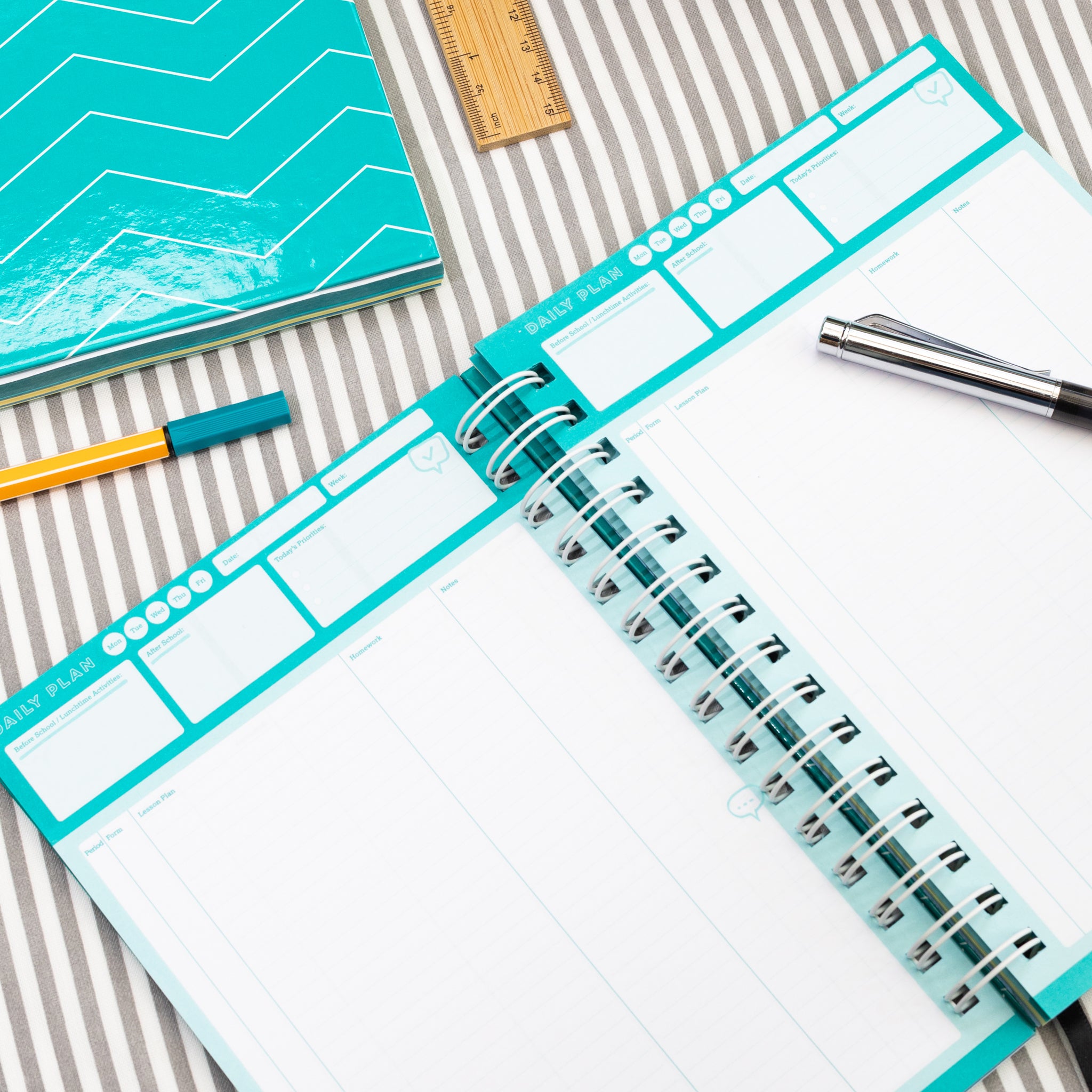 Flexi Period Teacher Planner Open On Daily Plan Page On A Striped Background, With Pens And A Ruler 