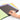 Hand Holding A Pencil About To Design Inside Assorted Covered Scrapbooks With Black Sugar Paper Inners On A White Background