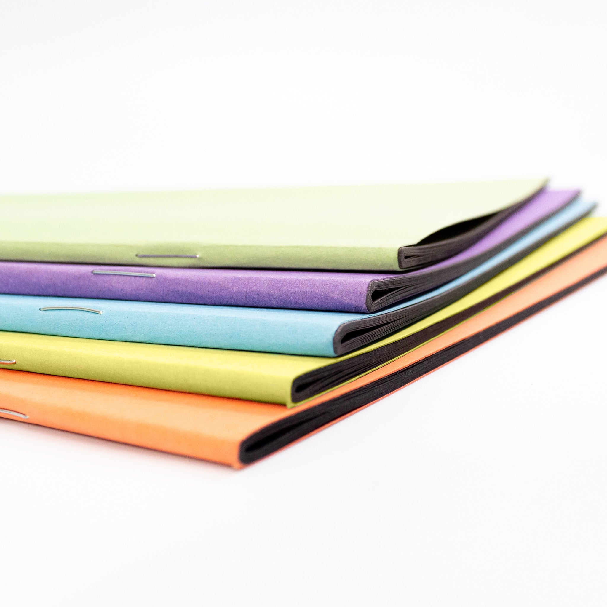 Assorted Covered Scrapbooks With Black Sugar Paper Inners On A White Background