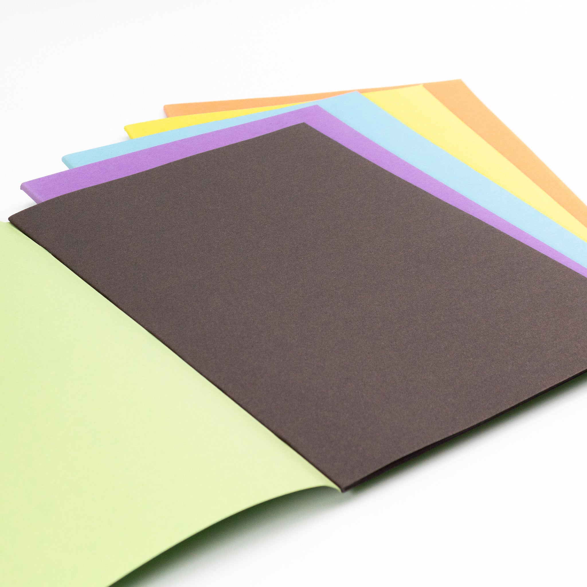 Assorted Covered Scrapbooks With Black Sugar Paper Inners On A White Background