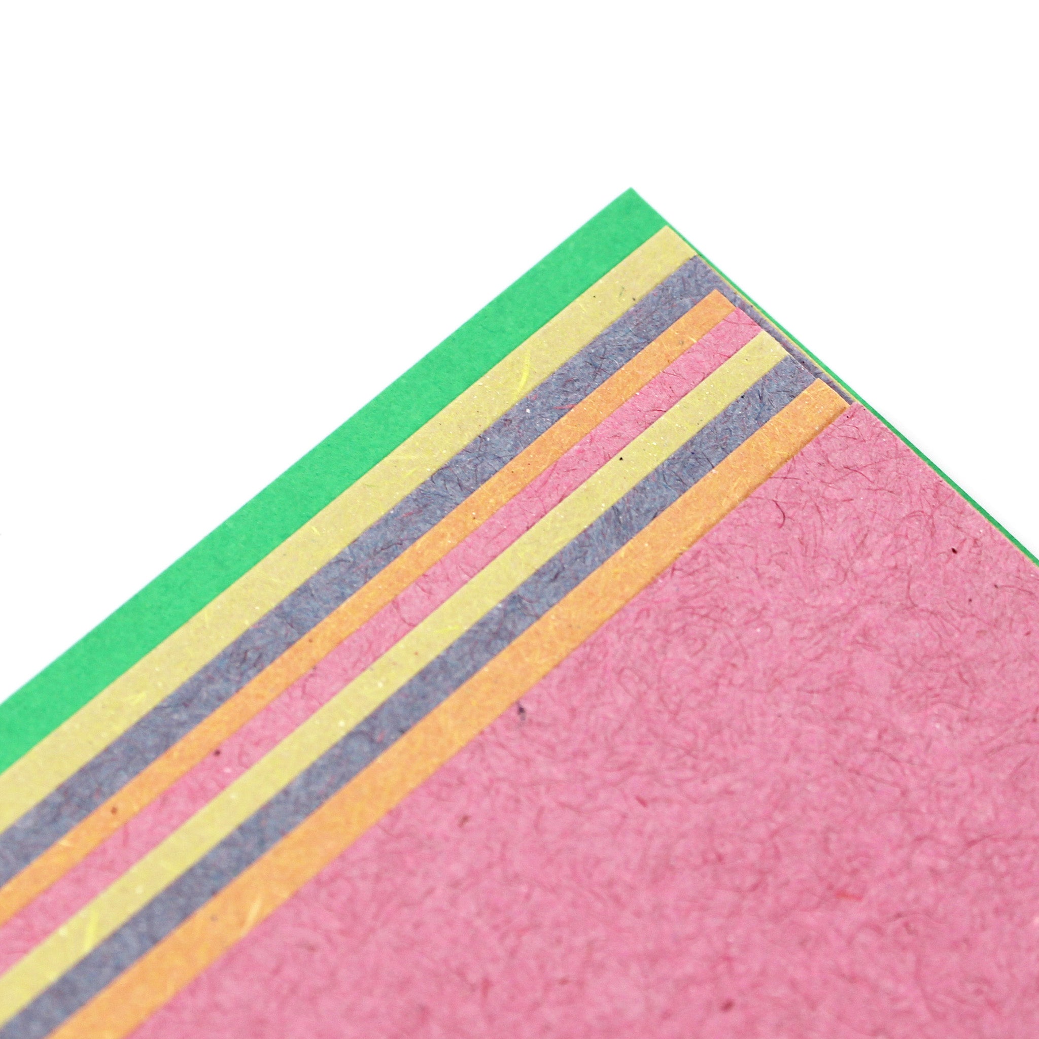 Close-Up Of Pastel Sugar Paper In Green, Yellow, Pink, & Grey On A White Background