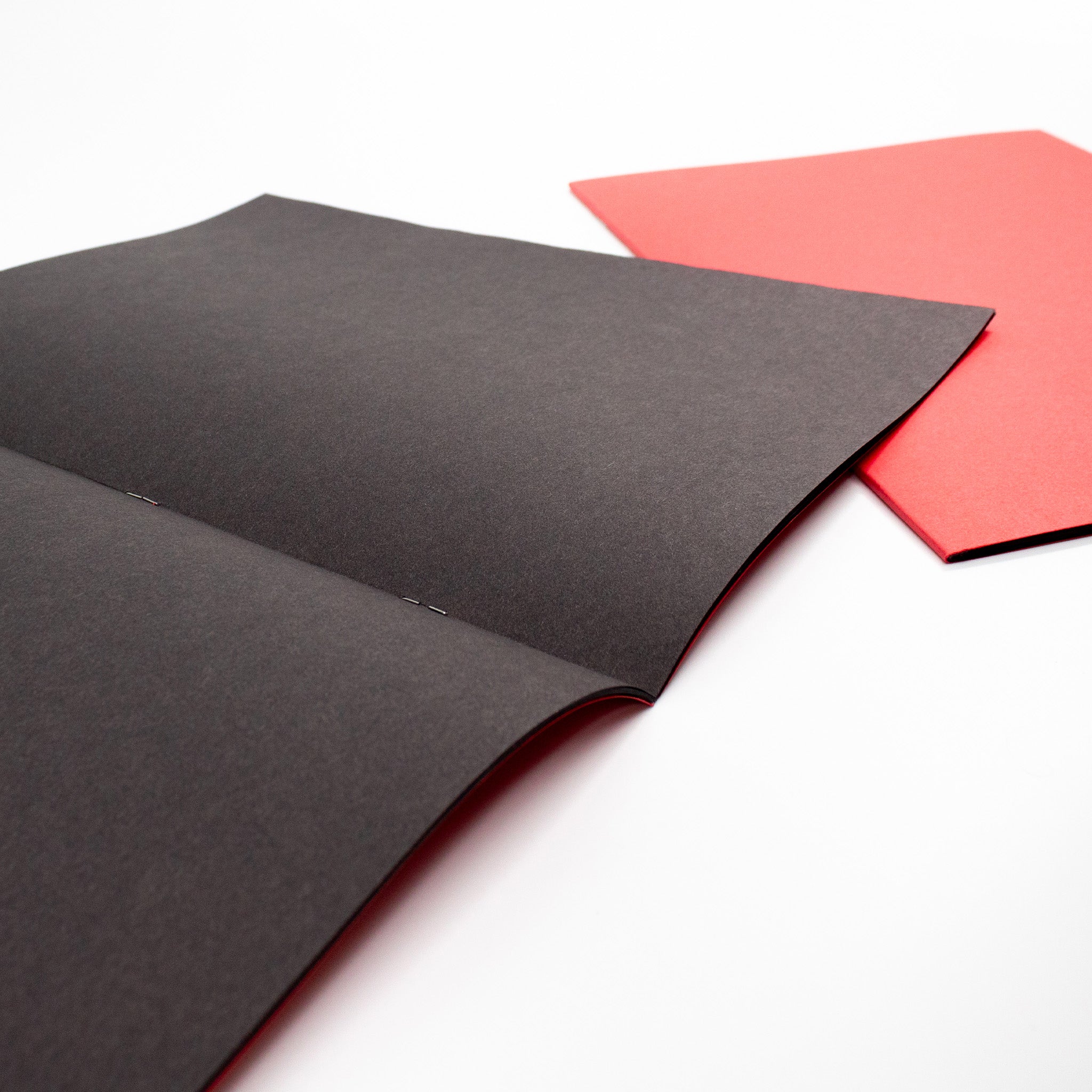 Two Silvine Red Cover Black Sugar Paper Scrapbooks For Classrooms On A White Background, One Open To Display Paper The Other Close To Display Cover