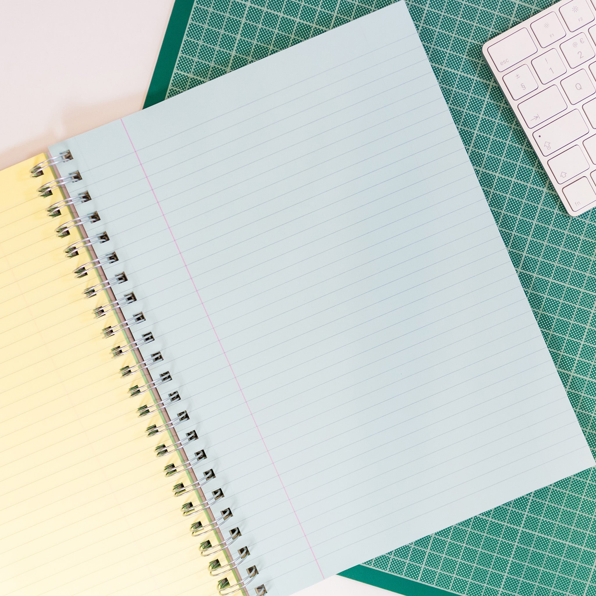 Silvine Project Notebook With 5 Tinted Paper Sections Open On Blue Lined Section On A Cutting Mat With A Computer Keyboard